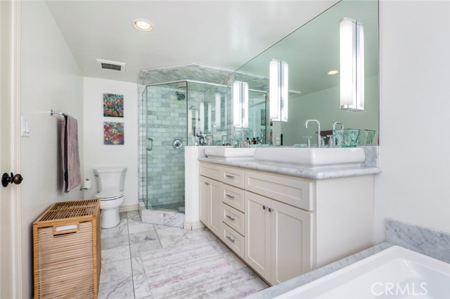 Master bathroom features dual sinks, a walk in shower...