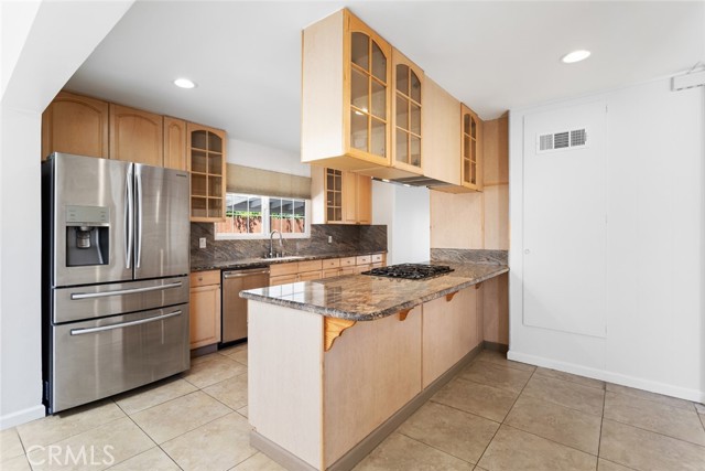 Kitchen with custom made cabinetry, with sleek gourmet granite counters.