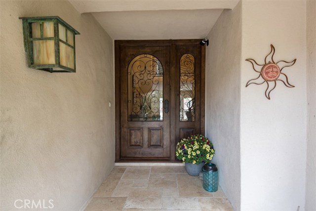 Lovely entrance with solid wood door and travertine stone entryway.