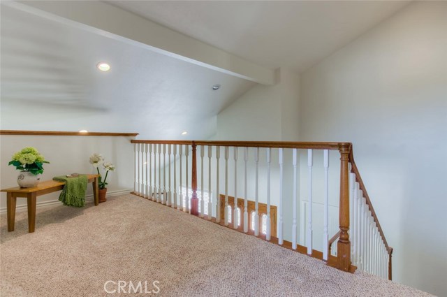 The elegant, wood staircase with new carpet leads to an oversized landing overlooking the entry.