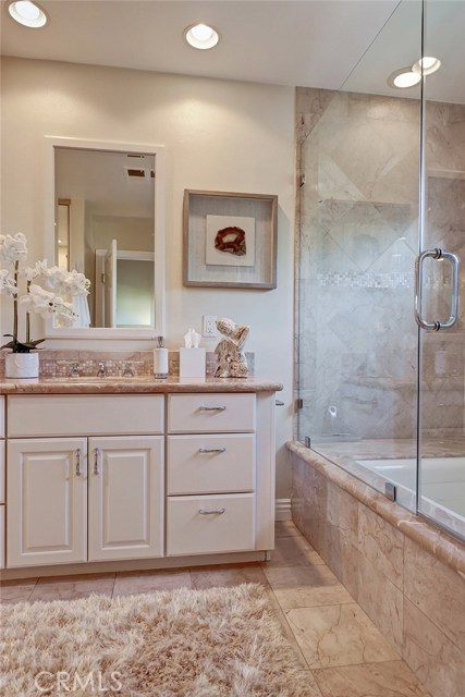 Recessed lighting, modern hardware details, and tile work completes this master bathroom.