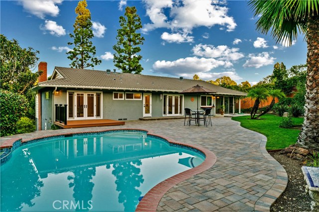 A beautiful yard that is well balanced with custom pavers, grassy area,  nice deck off the master bedroom and a garden with many different fruit trees.