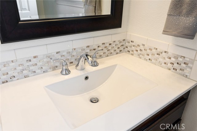 Guest bathroom remodeled with new vanity and tiled back splash.