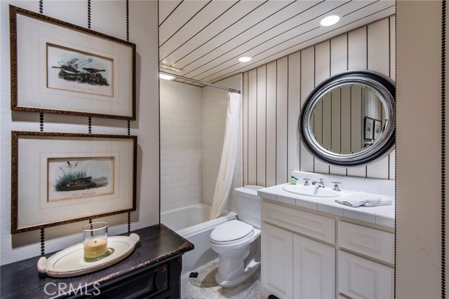 The downstairs guest bath is just across the hall from the lower guest bedroom. Interesting wall covering adds the perfect touch!
