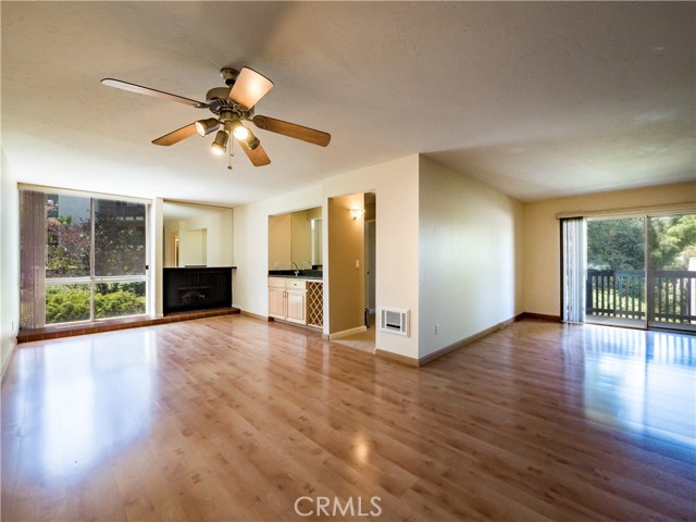 Laminate wood floors, floor to ceiling windows, gas fireplace, smooth ceilings, ceiling fan, granite counter at the remodeled wet bar with wine rack, large baseboards. Beautiful natural light and views.