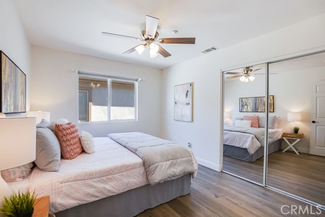 Bedroom Two with ceiling fan and plenty of closet space with mirrored doors.