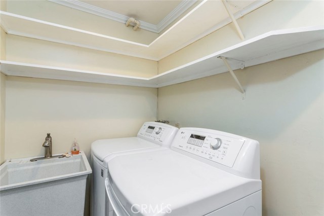 Laundry room with shelves and utility sink