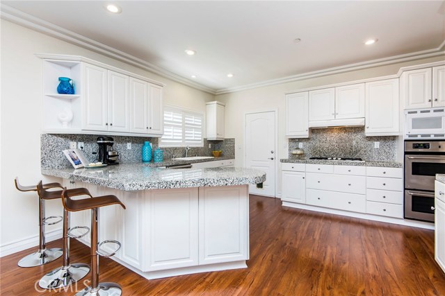 Kitchen with huge counter space, thoughtfully built upper cabinets high enough to fit Espresso machine, Kitchen-Aid mixer and most any appliance underneath. Door is direct access to attached garage.