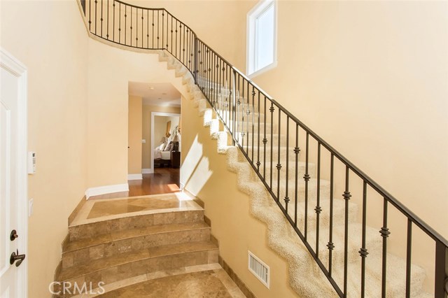 Entry way from ground level. Straight ahead is the master suite. Before master suite to the left is the wooden staircase to the lower two bedrooms. The stairs to the right of the image lead to the living room, dining, kitchen, and balcony access.