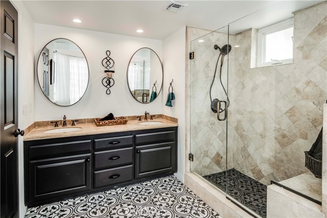 All three baths feature natural stone and imported Spanish deco tiles.