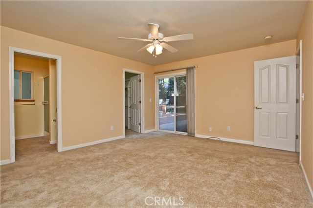 Master bedroom with walk in closet, master bathroom and sliding glass door leading to back yard