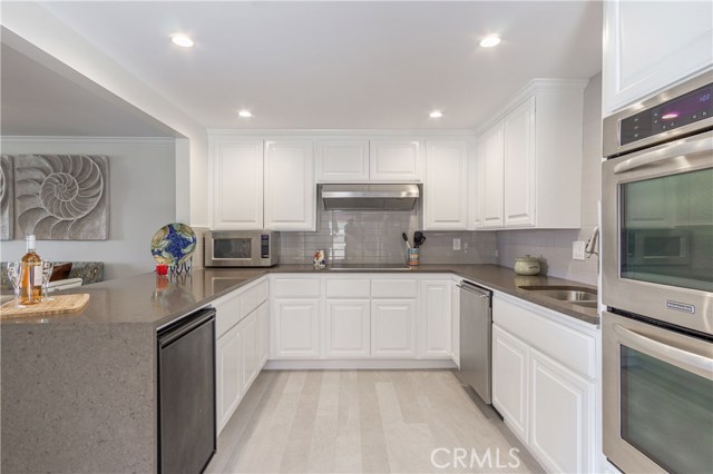 White cabinetry, neutral tones, double ovens, wine refrig
