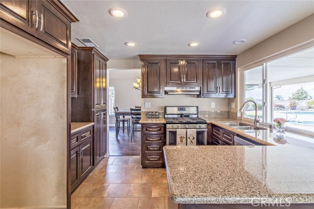 Gorgeous kitchen! Dark wood cabinets accented by neutral granite counter tops.