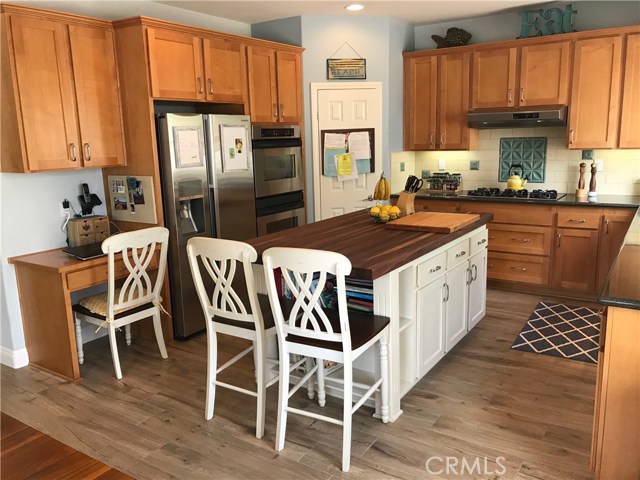 Kitchen has a computer area, island seating, new floors, lots of space