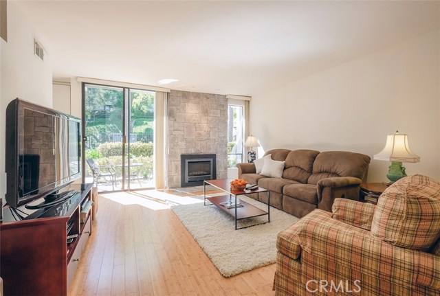 Light and bright living room, with custom stone fireplace, bamboo floors, recently painted througout