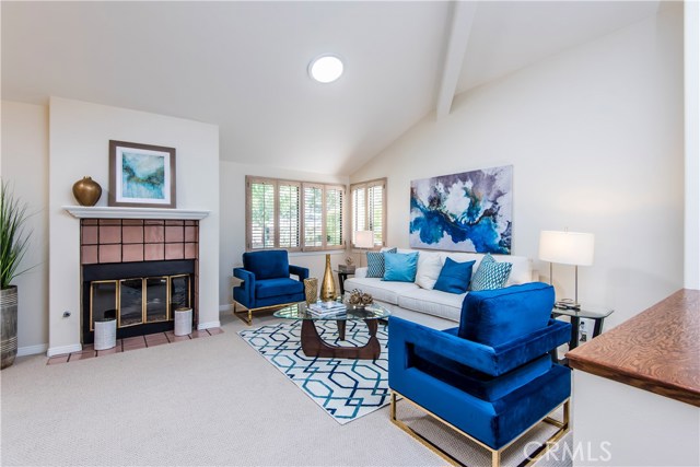 Living room with fireplace an high vaulted ceilings and skylights