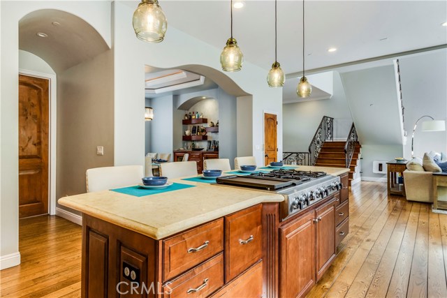 Another Vantage point of kitchen island with 4 burner gas stove and a breakfast bar