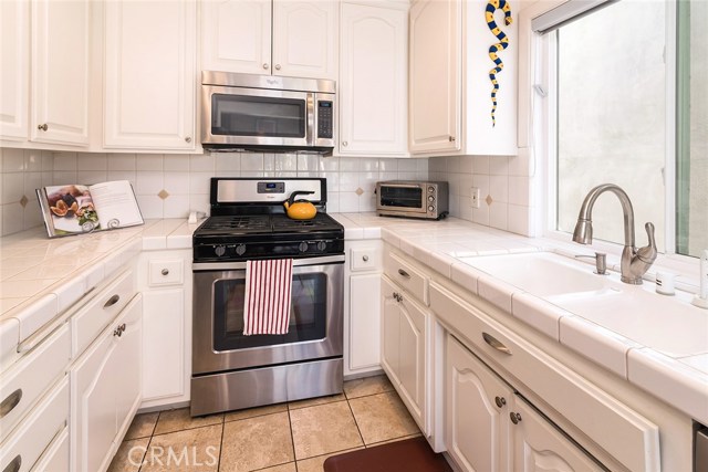 Kitchen with a sunny west facing window and stainless appliances.