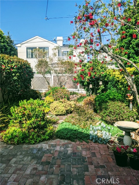 charming back yard with old growth and used brick walkways to back storage area.