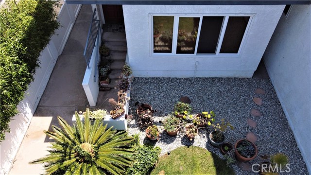 Stairs to front door. The area in front of the windows would be considered "common area". The current owners of unit D take care of their plants and treat it like it is their own yard even though it is common area. The other owners do not spend any time in this area.