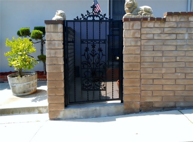 Side Wrought Iron Gate Leading to Backyard, Utility Room and Side Cemented Yard Surrounded by Block Walls.