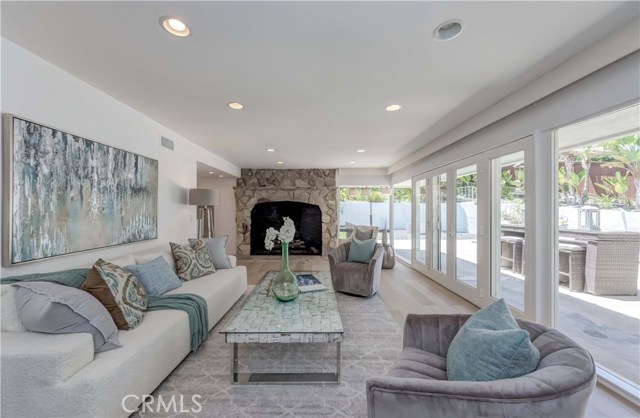 Family room with a giant stone fireplace, wet bar, French-doors to outside patio