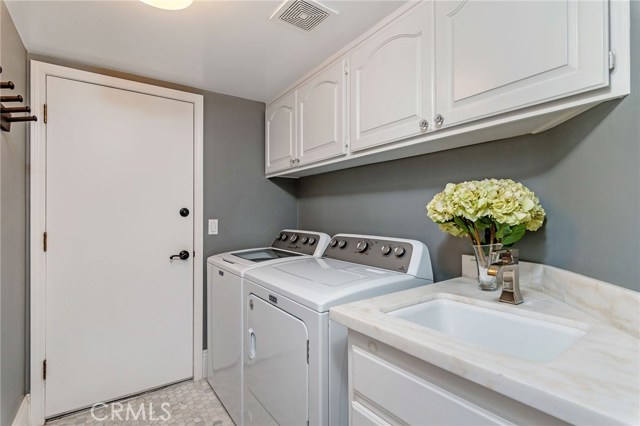 Laundry room w/sink & storage and direct access to garage.