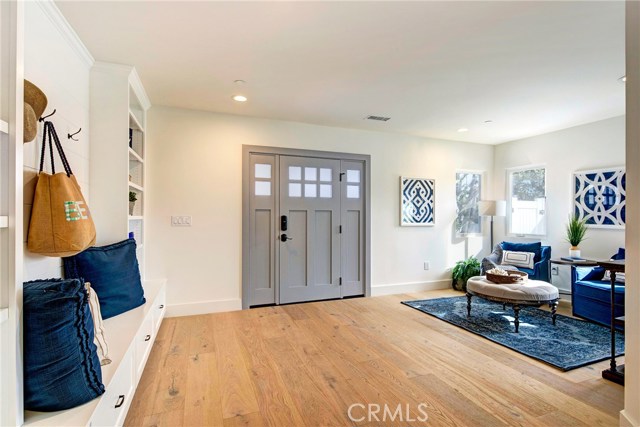 Entry way with sitting area, cubbies, shelves, storage doors, and coat hooks.  Beautiful French Oak flooring throughout.