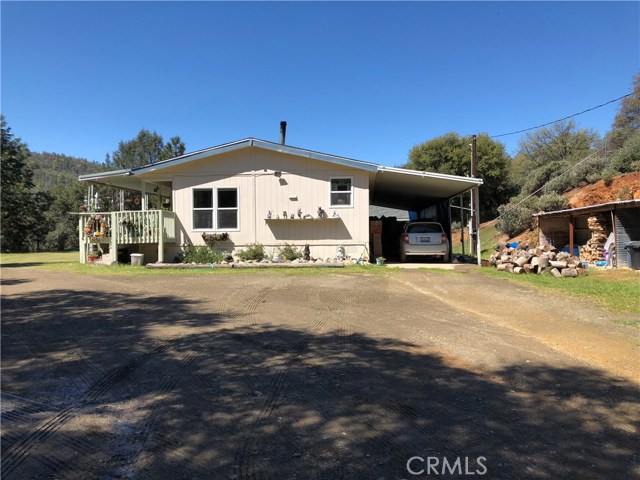 Home with attached carport, and large wood shed.