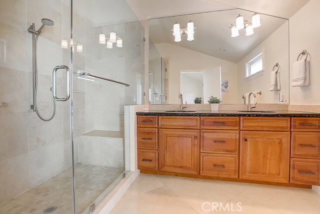 Master Bathroom showcasing double sinks and step in shower with bench.