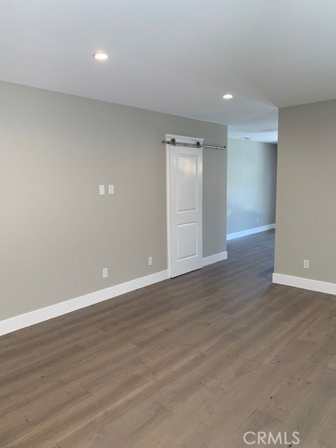 Living room view facing entrance to kitchen and backyard.  Also, barn door for downstairs bathroom.