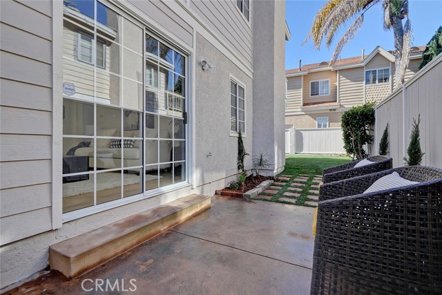 Side patio leading into formal living room and wrapping around to back yard