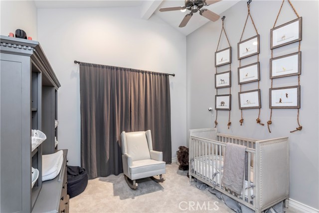Designer 2nd bedroom/nursery with vaulted ceiling.