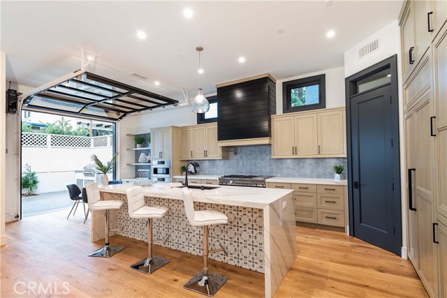 The "Dream" Kitchen with Professional Chef style appliances. Lots of custom, solid wood cabinets, with custom wood panels for the Jenn-Air built in refrigerator and Bosch Ultra Quiet Dishwasher. Under cabinet outlets and lighting provide a clean look. Designer tile for the backsplash. The oversize shelves in the pantry accommodate larger boxes and appliances.