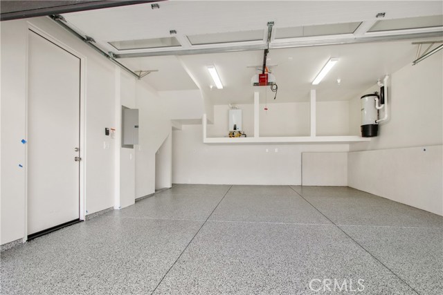 2 Car Garage with Epoxy Flooring, central vacuum unit and tankless water heater.   Storage area for a second fridge in the corner.
