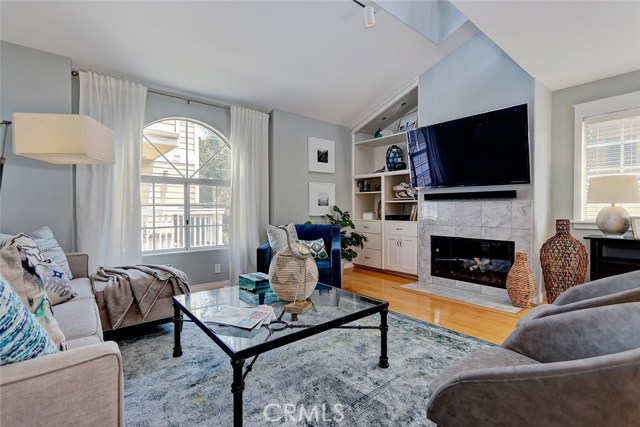 Cozy living room with vaulted ceilings, fireplace, and built-in shelving.