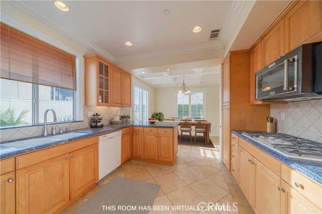 Spacious kitchen with view to the sunny dining area and outdoor spaces