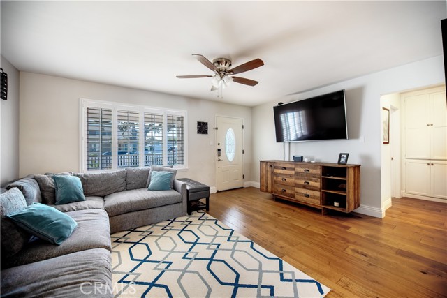 Wondeful living room with large window, plantation shutters, hardwood floors opens to the kitchen