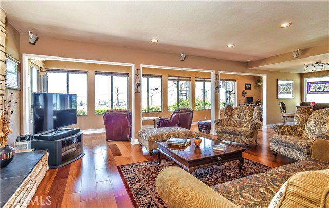 The great room / living room is fronted by a wall of West facing windows which open onto the panoramic ocean and sunset views, flooding the home with light and ocean breezes.