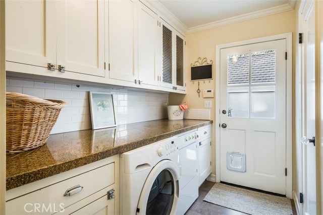 A very efficiently-designed laundry room between the kitchen and garage, with a handy half bath to the right.