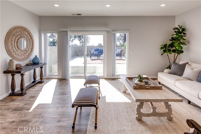 Enter the living room, filled with natural light which is spacious enough to entertain and features sliding glass doors that lead to a large patio that over looks the park
