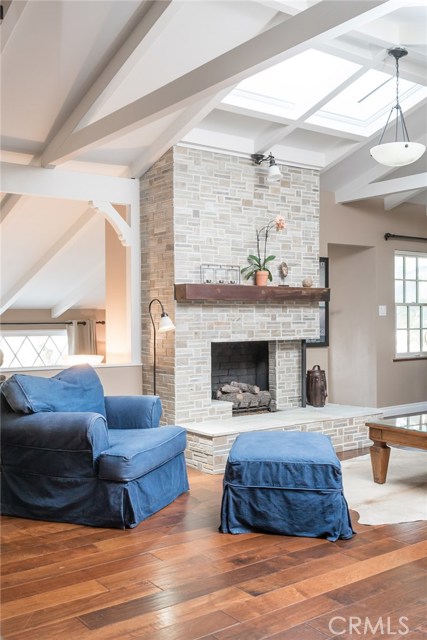 Loft-like Family Room Enjoys Wood Beams, Vaulted Ceiling and Beveled Travertine Tile Work on Fireplace