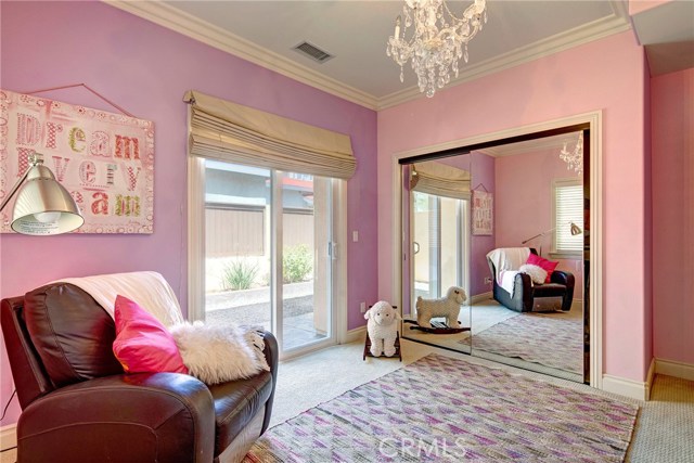 1st of two large bedrooms downstairs, crown molding, spacious closet, and access to the backyard.