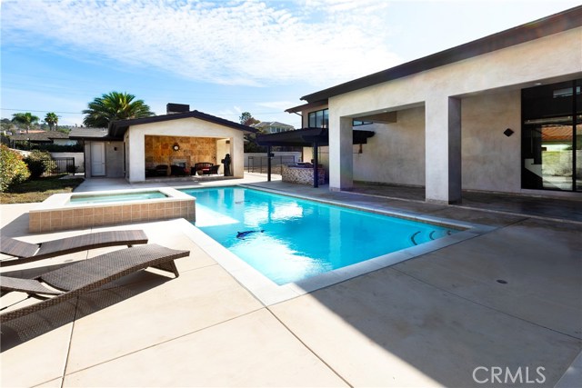 Pool/spa with covered patio & barbecue area on the right.  Covered entertaining area w/fireplace is just in front of the guest house.