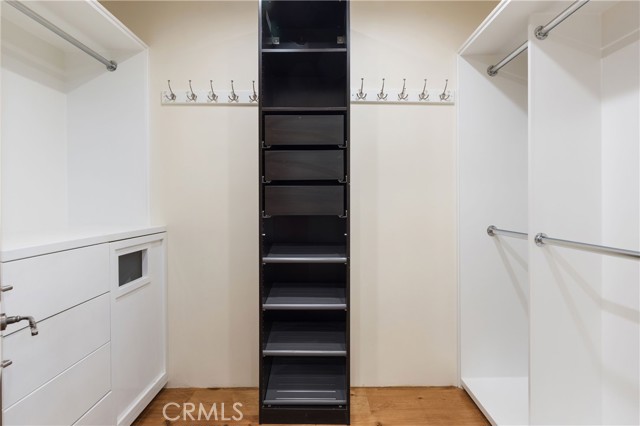 Walk in closet in primary suite with laundry chute.