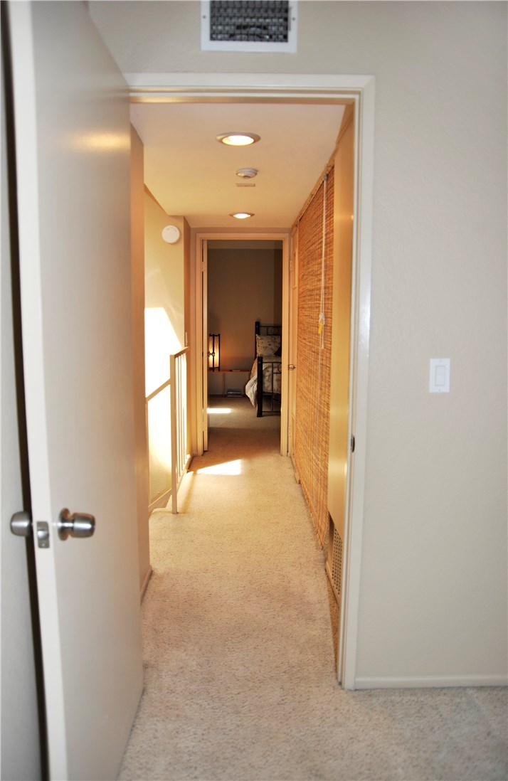 Hallway separating master suites.