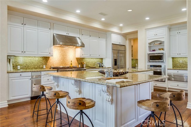 Gorgeous granite on the counters and backsplash in this large kitchen with Thermador 6 burner range with another stainless steel refrigerator, oven, microwave, and warmer.  Plenty of room to sit on the island and share in the kitchen festivities - where everyone always likes to gather.