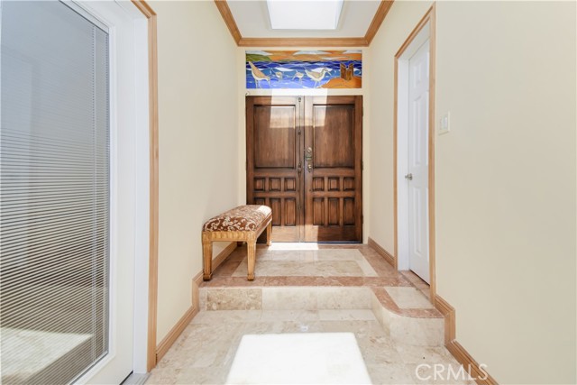 Entry hall with stained glass and beautiful floors and nice baseboards and crown molding.