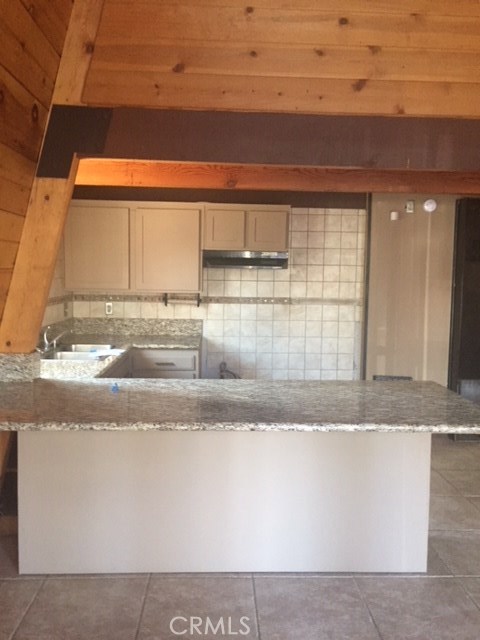 Kitchen has bar countertop made of granite