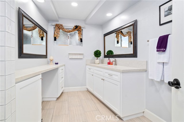 Downstairs bathroom with quartz tops, tile floors and custom cabinets.